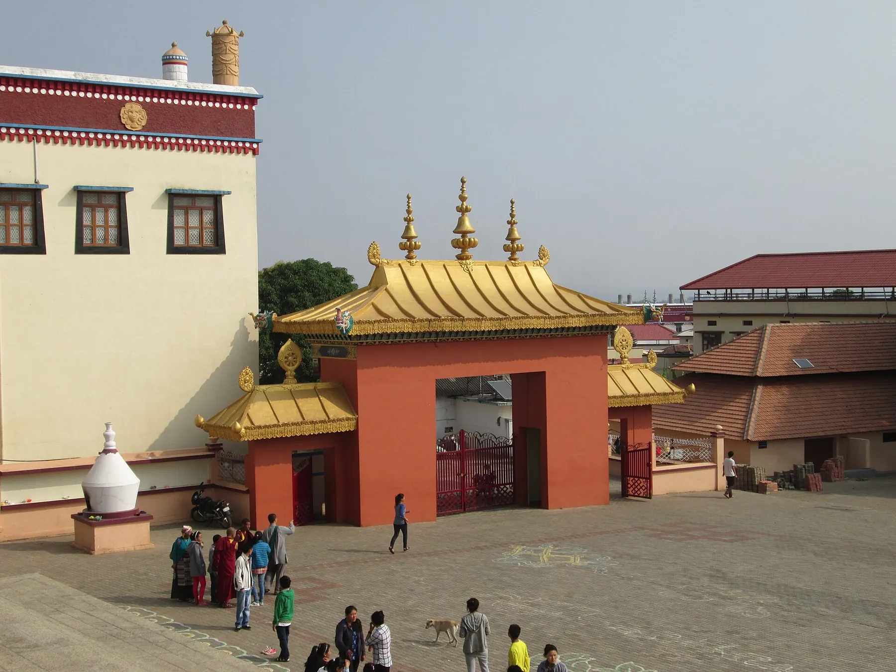 The gilded ceremonial gate of Sera Jey Monastic Institute at Bylakuppe, seen across the assembly courtyard